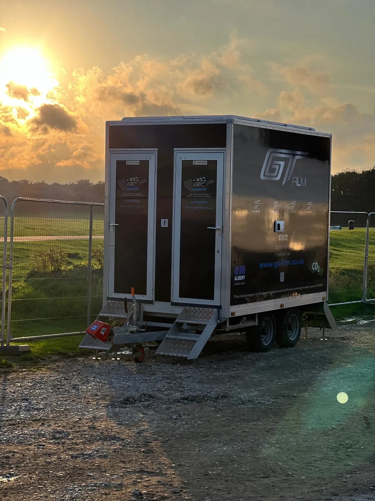 A portable toilet sitting on top of a dirt field.